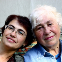A middle-aged woman and a senior woman sitting on a couch